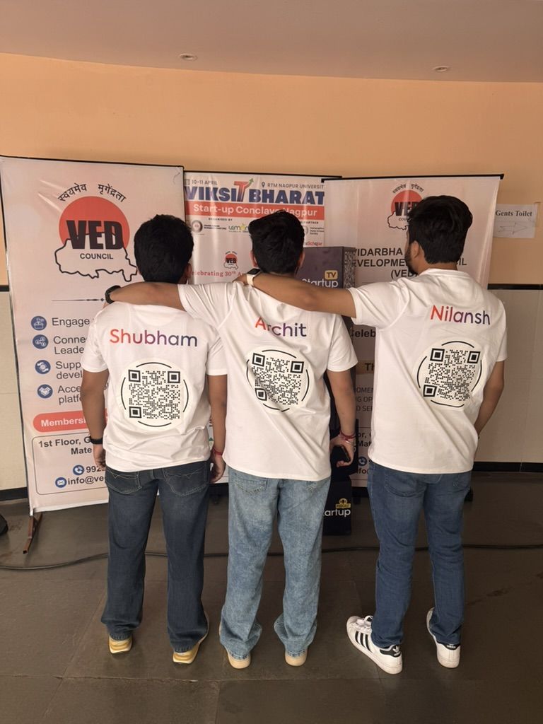 Shubham, Archit, and Nilansh showing Nimitai QR codes on branded t-shirts at the VED Council Viksit Bharat Conclave